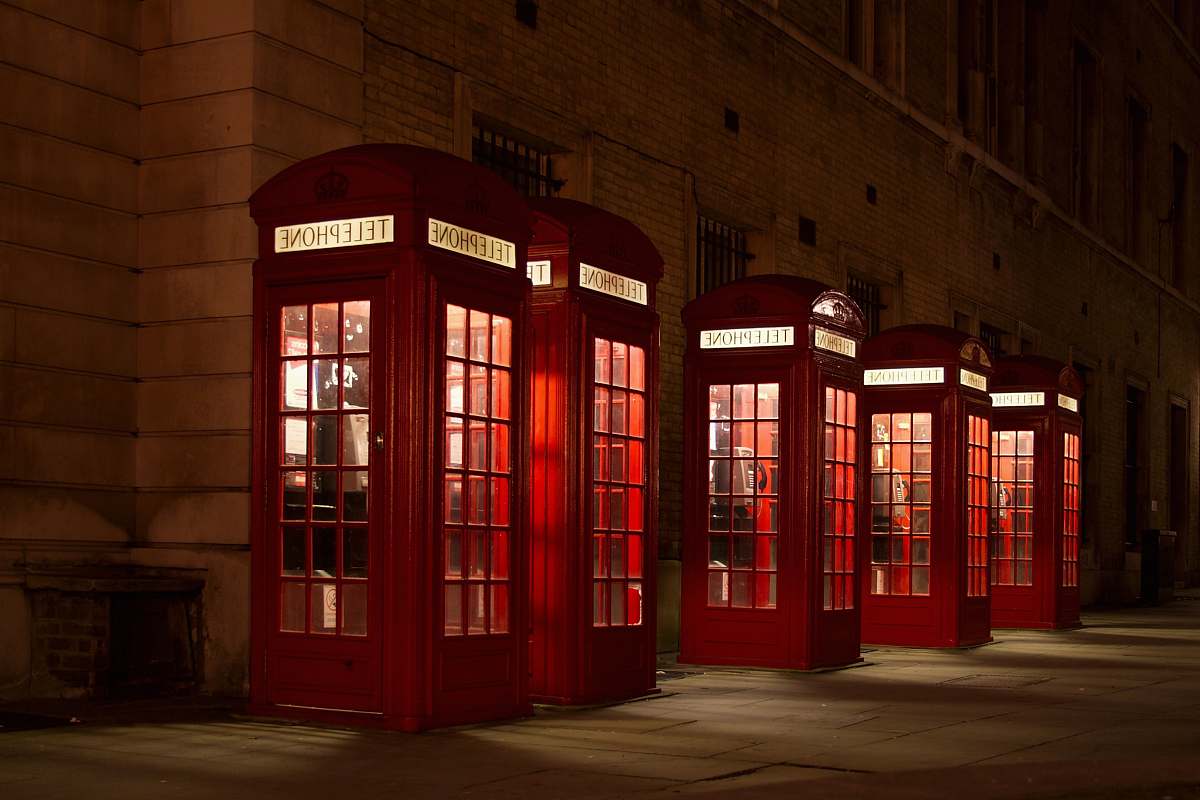 phone booth five red lined phone booths near building phone